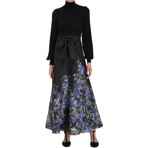 Model wearing floral maxi skirt and black sweater on white background.