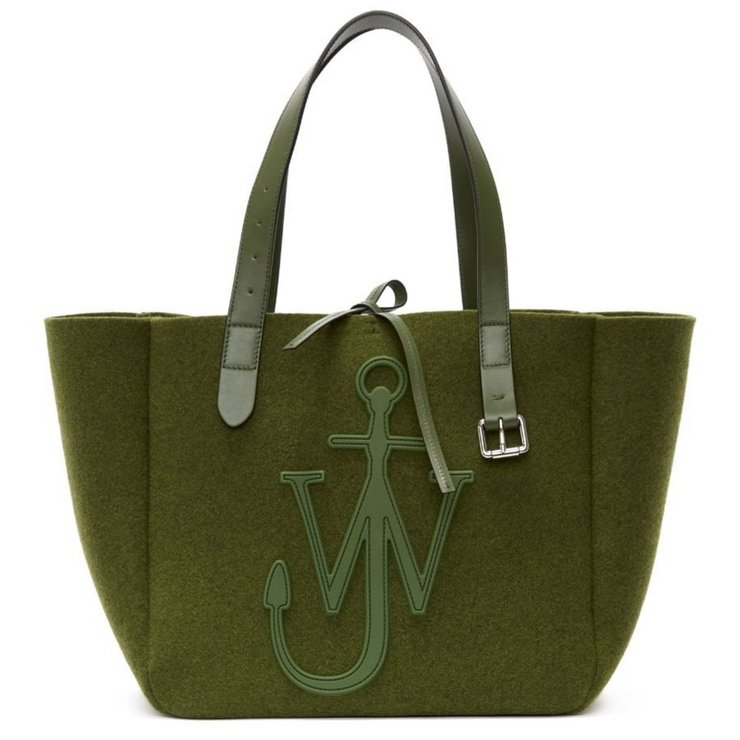 Front view of a polyester blend khaki tote with a leather tie closure. The tote has matching leather straps with a silver buckle hanging from the right strap. A large leather brand logo is featured on the front. The tote is shown in its entirety against a white background.